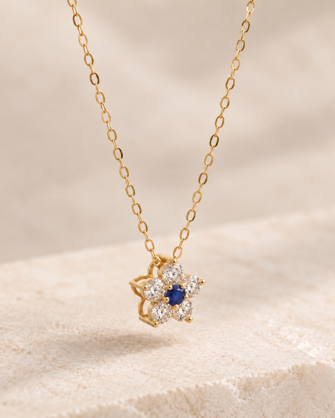 EVELYNNIE Floral Pendant Necklace in 18K yellow gold with blue sapphire center and natural diamond petals, three-quarter view