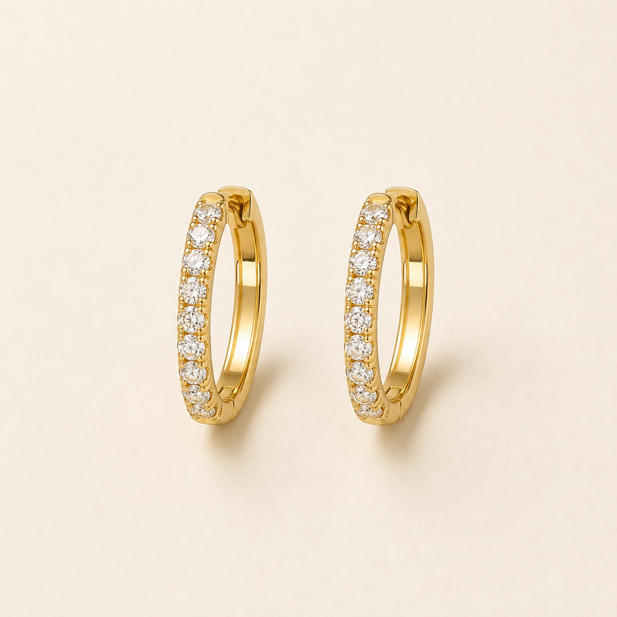 EVELYNNIE pavé huggie hoop earrings on warm ivory background